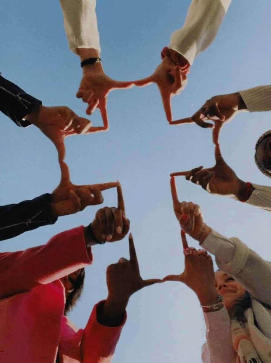 Teenagers forming a cross with their hands